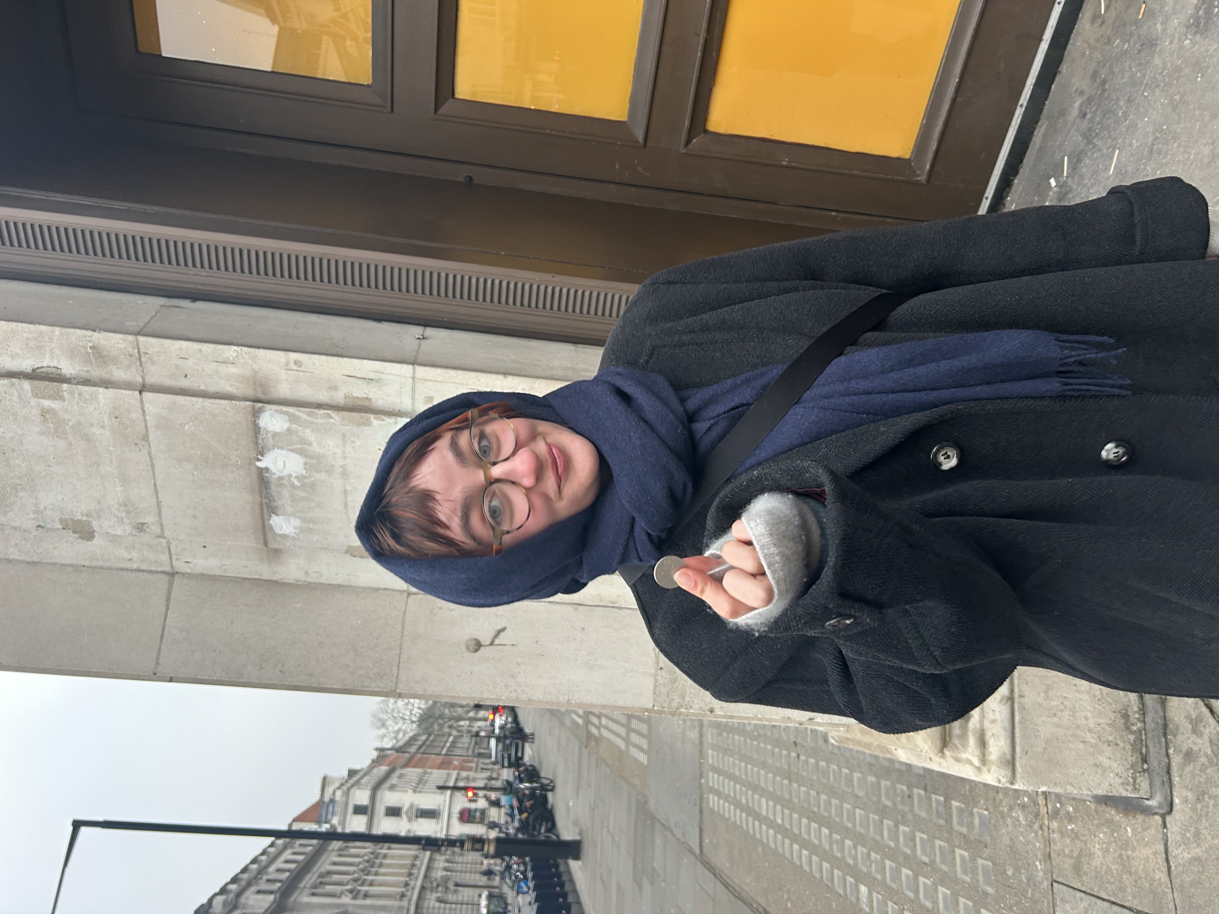 Virginia Edwards holding a ten-pence coin on a London street